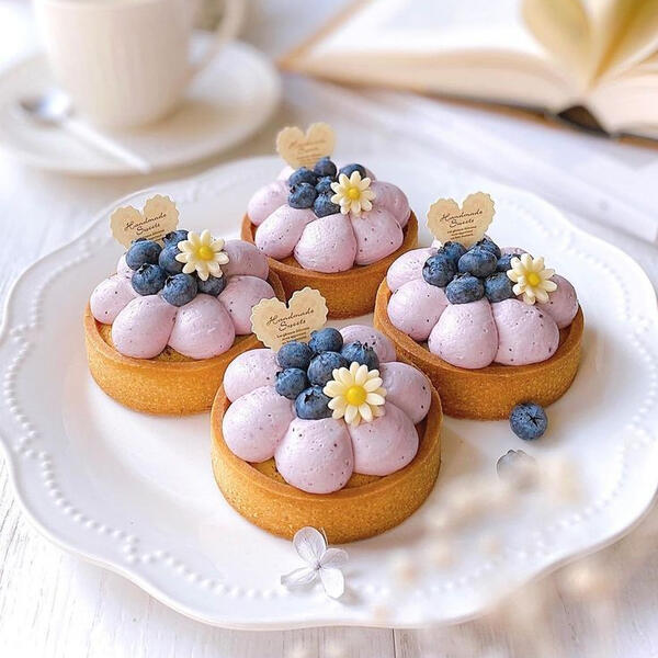 Blueberry Daisy Tarts - Made with house-made fresh blueberry cream infused with daisy syrup atop a honey tart pastry and decorated with blueberries and handmade sugar daisies.