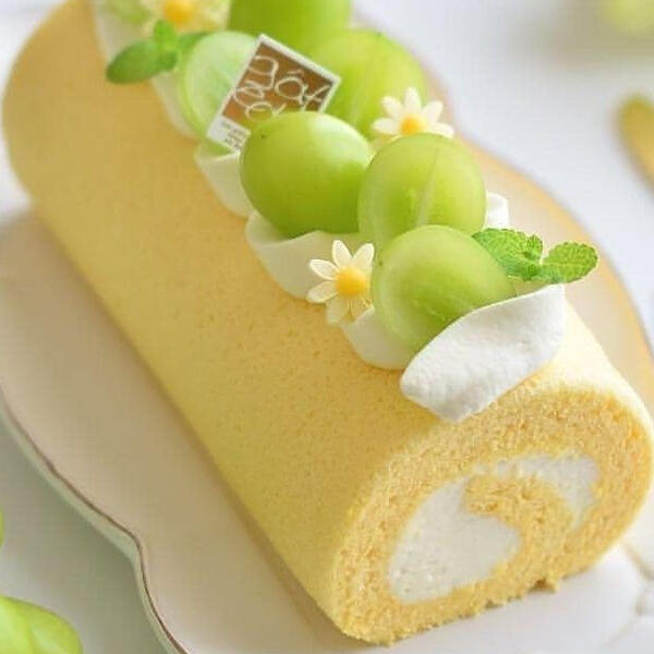 Spring Cake Roll - Made with homemade lemonade infused sponge cake wrapped around sweet house made whipped cream and topped with fresh cut green grapes, fresh mint leaves and honey sugar flowers.