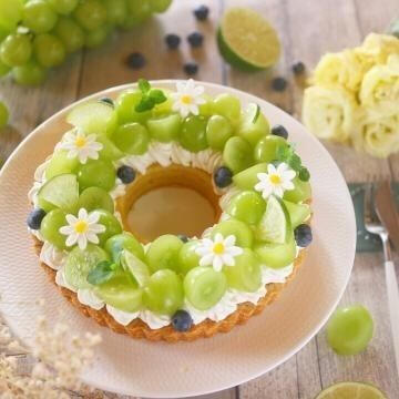 Blueberry Green Grape Tart - Fresh cut green grapes combined with fresh blueberries and hand made sugar flowers atop a bed of house made vanilla whipped cream coating a soft cinnamon tart cake.