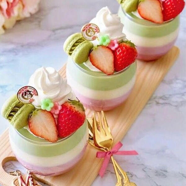 Bubble Tea Custards - Fresh ground matcha and taro infused custard with a layer of fresh brewed milk tea custard in between, topped with fresh strawberries, house made whipped cream, handmade candied flowers and a mini matcha macaron.