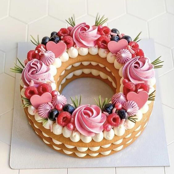 Berry Bouquet - Made with white chocolate cream layered between sweet light cake topped with berries, handmade edible grass, berry wafer hearts and house-made berry frosting pipped into roses